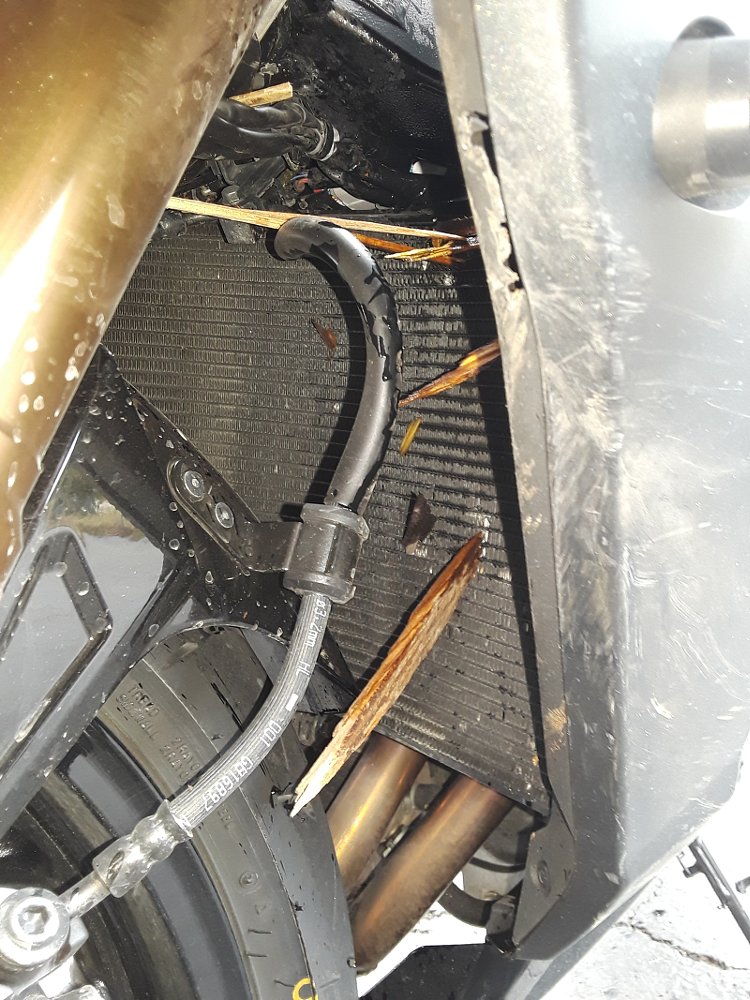 close up of sharp shards of wood sticking into a leaking radiator