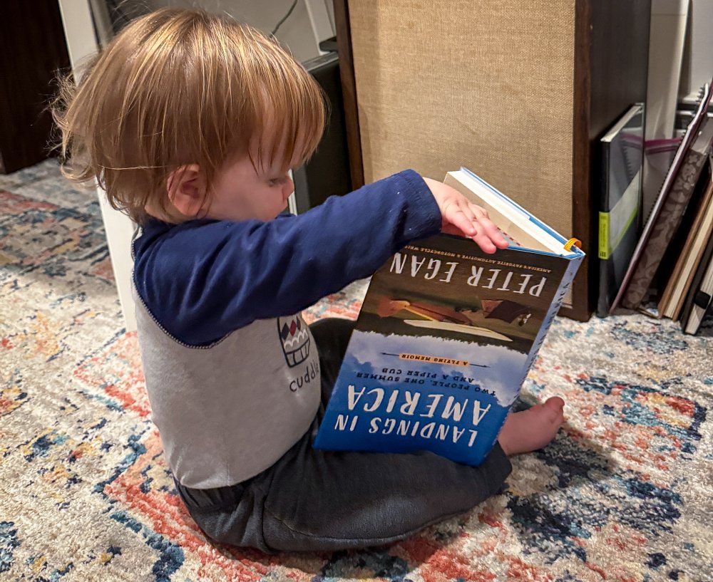 Mini Spurg reading Peter Egan with the book upside down