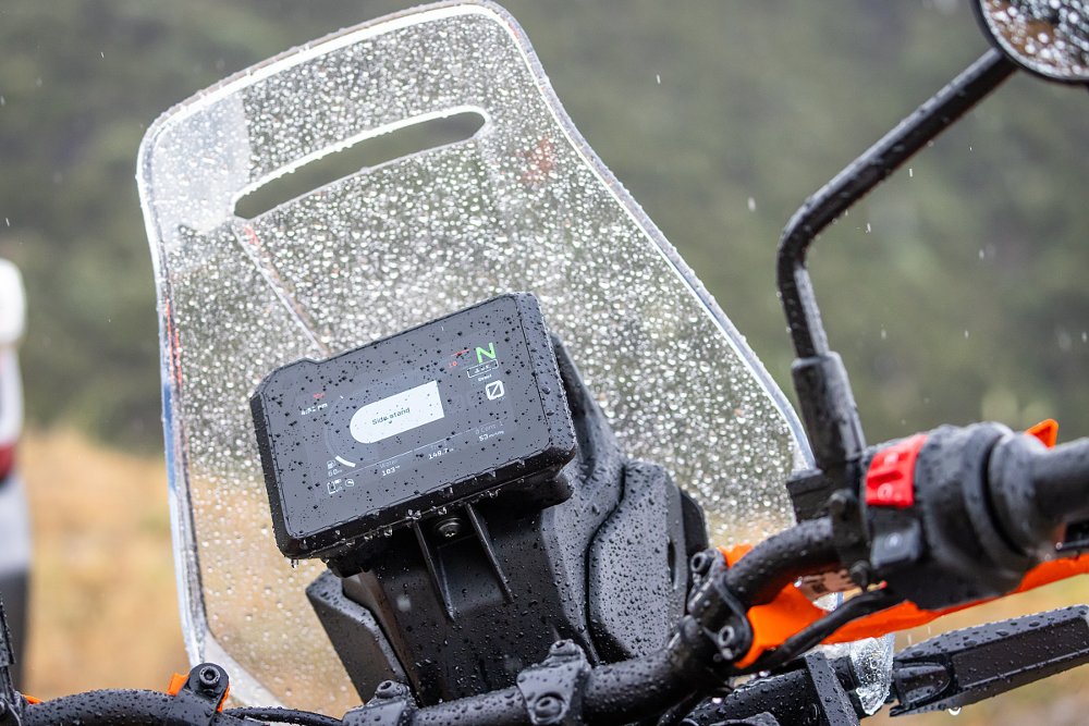 view of the cockpit of a KTM 390 Adventure R with a TFT display with rain on the windscreen