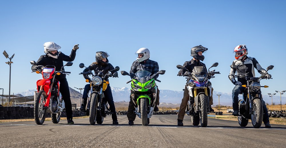 five riders lined up on a variety of beginner motorcycles