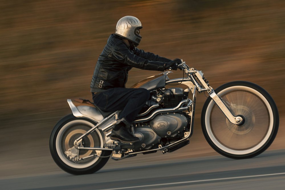 chopper style Royal Enfield custom motorcycle with two engines being ridden