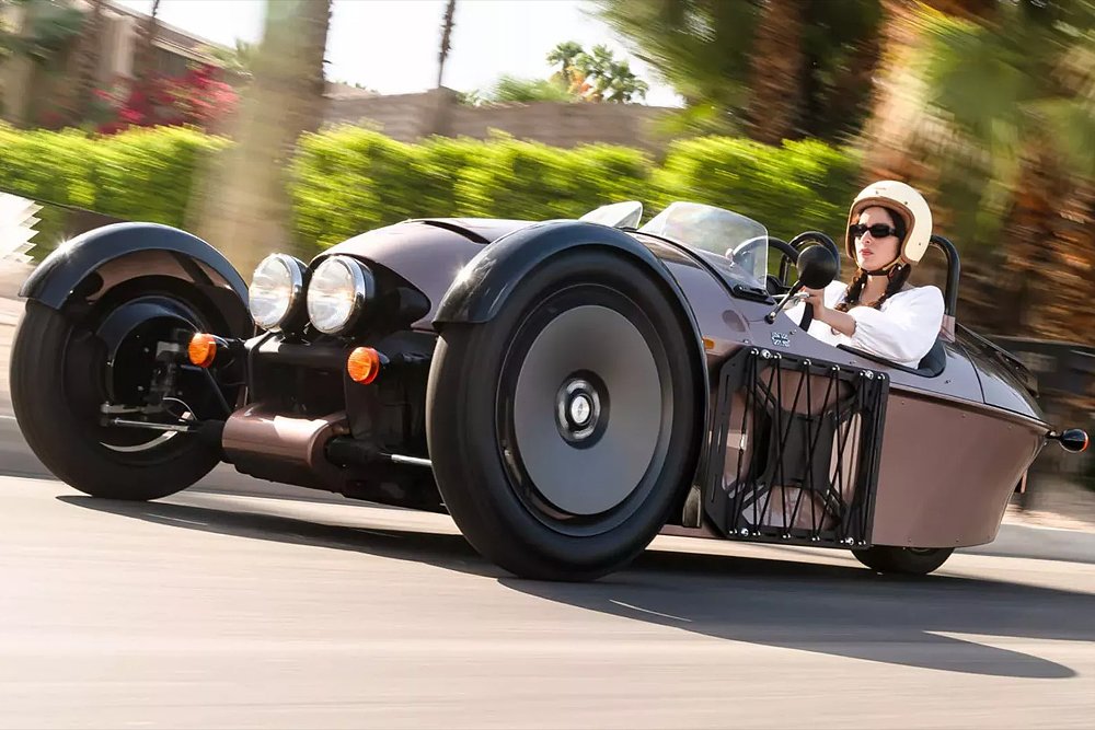 A female rider drives the Morgan Super 3 down an urban road.