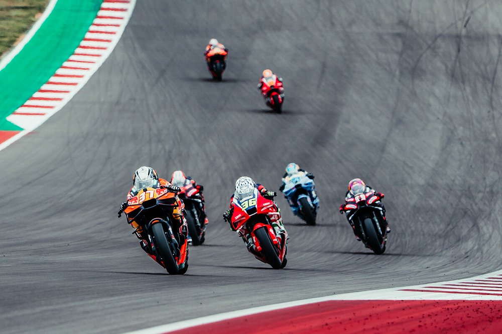 MotoGP racing motorcycles sprint down the back straightaway a the Red Bull Grand Prix of the Americas in Austin, Texas.