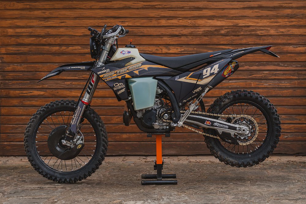 side view of the off-road motorcycle on a stand, showing many carbon fiber parts