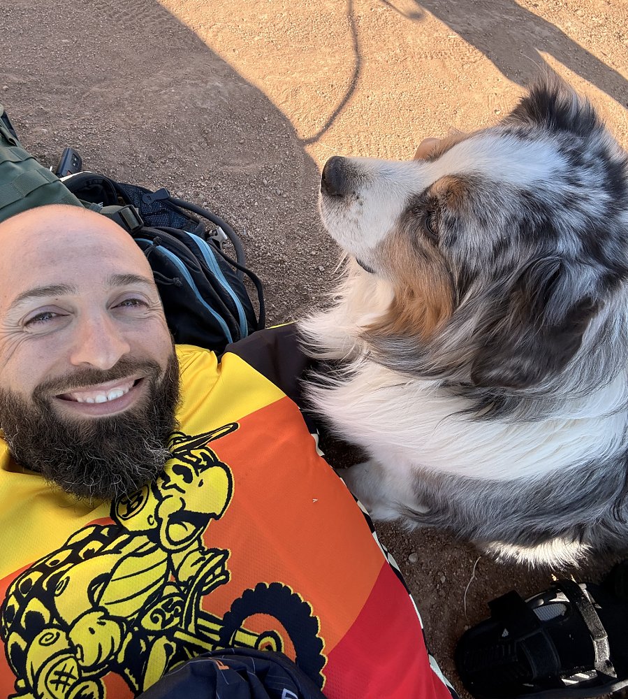 an Australian Shepherd watches over the author as he lies on the ground