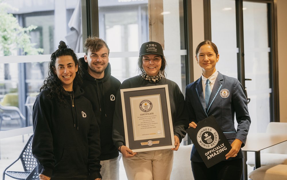 the three riders posing with a Guinness World Record certificate and a woman representing Guinness