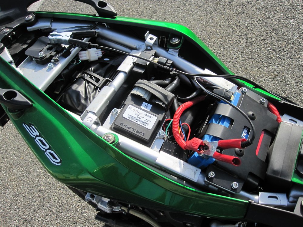 Accessing a motorcycle battery by removing the seat.