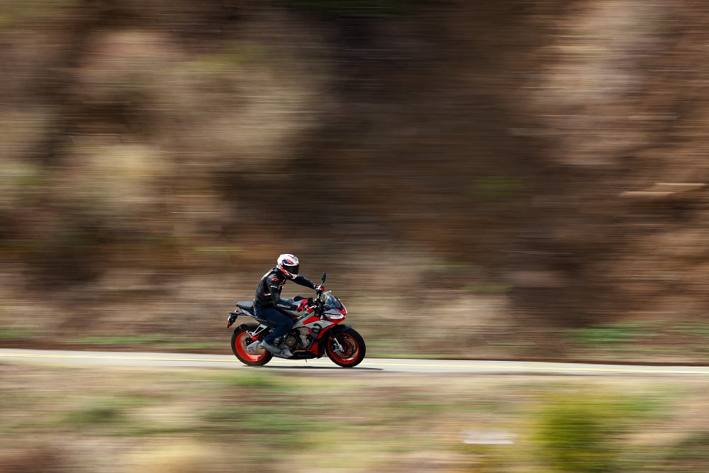 side shot of Aprilia Tuono 660 riding along a mountain road