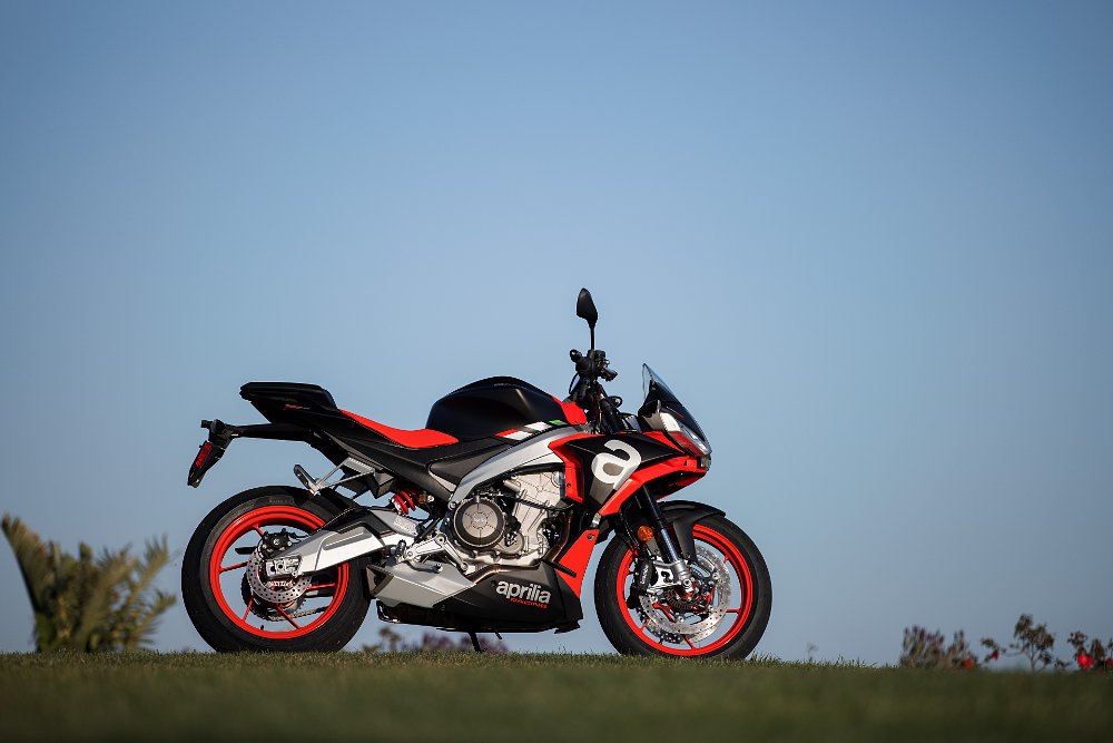 Aprilia's Tuono 660 sitting on a hill overlooking the ocean