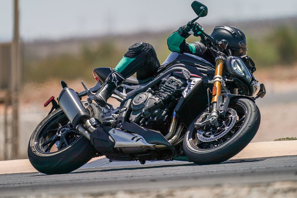 female rider leaning through left hand corner on Triumph Speed Triple 1200 RS motorcycle