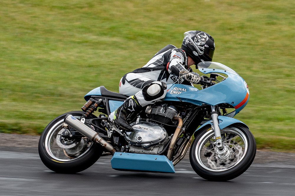 Trisha pilots her bright blue race motorcycle around the race track.