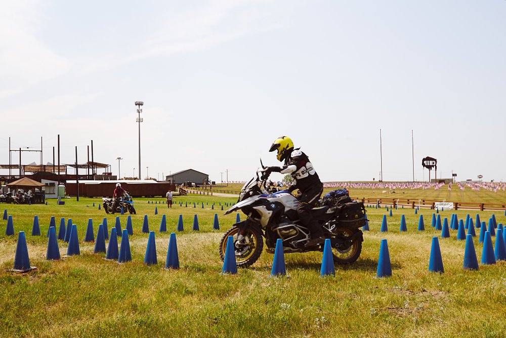Big ADV bikes take turns riding through a tight cone course to test their skills.