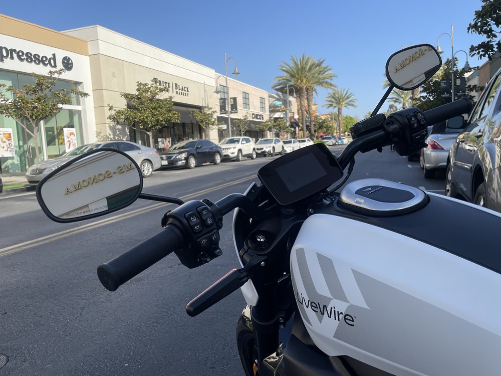 Photo of the LiveWire ONE handlebars with a view of a suburban mall in the background
