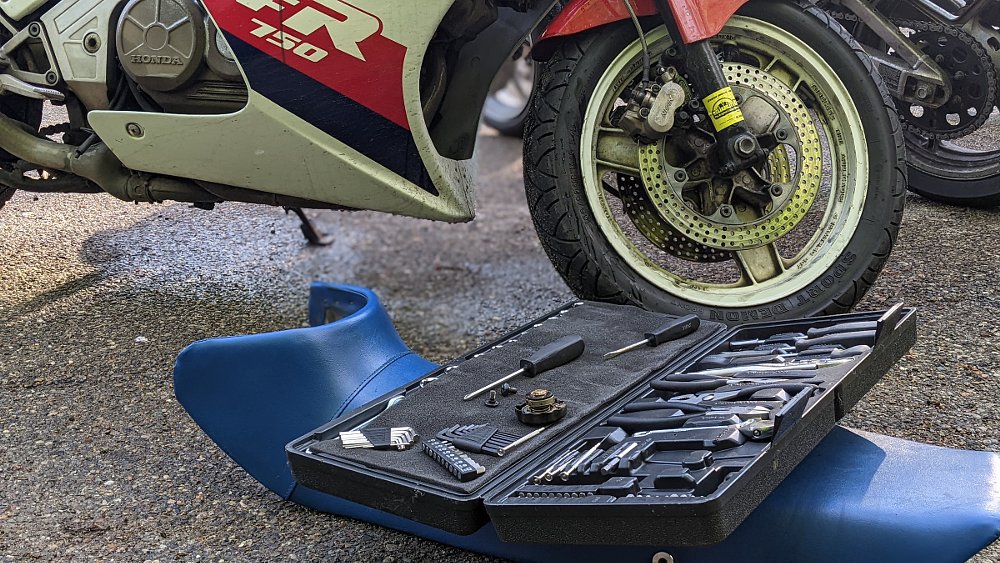 tool kit beside a parked old motorcycle