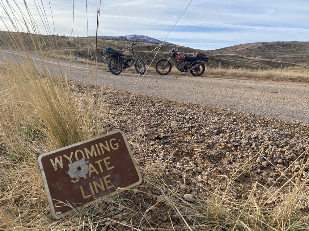 Wyoming state line sign, with bullet hole. 