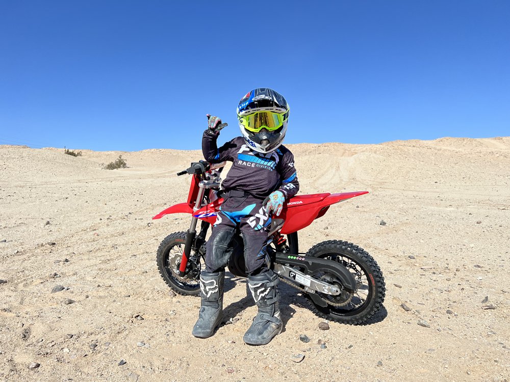 Child rider posed with Honda CRF-E2 electric mini dirt bike.