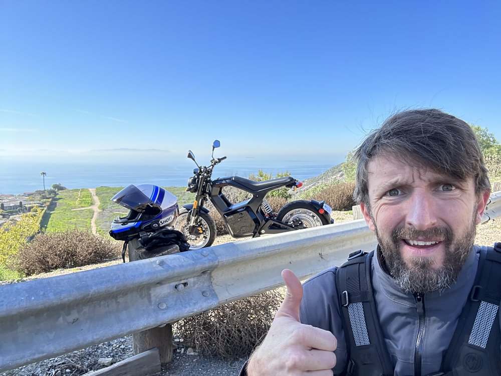 Self-shot photo of Zack with the Sondors MetaCycle, overlooking the Pacific Ocean