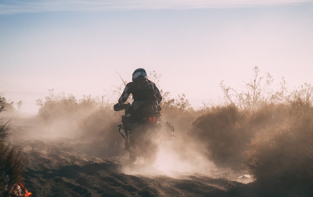 riders in the dust cloud in the desert