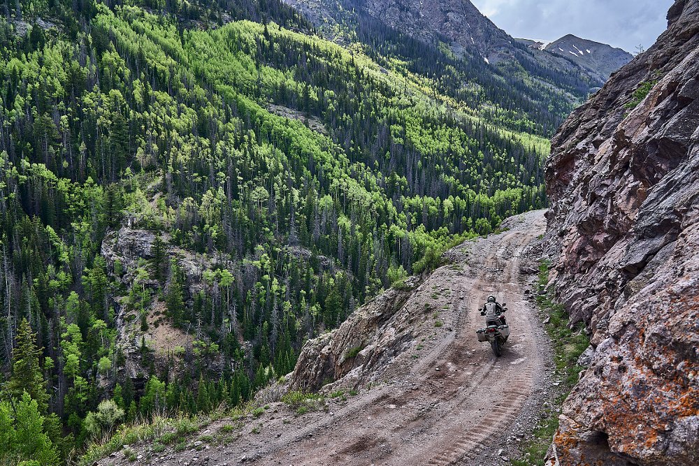 long view of riding on a mountainside dirt road