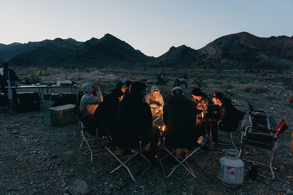 riders gathered around a campfire at twilight