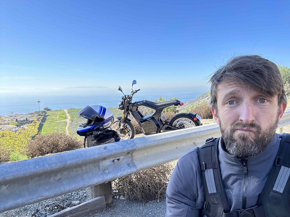 A selfie of a rider with a Sondors Metacycle sitting on the side of the road.