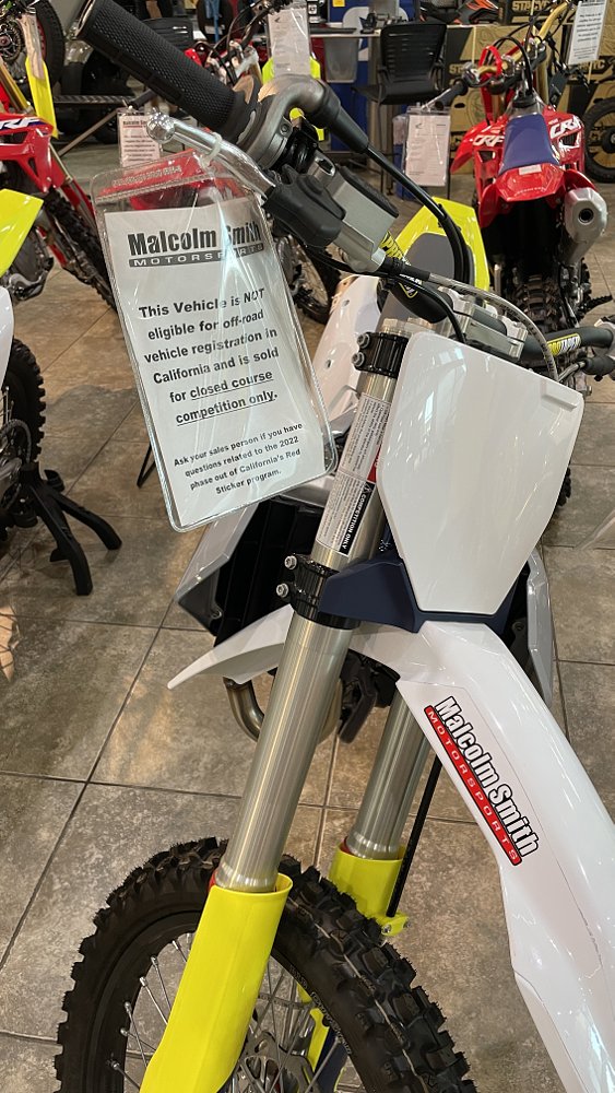A dirtbike has a hangtag on the handlebars that say in bold print for private land