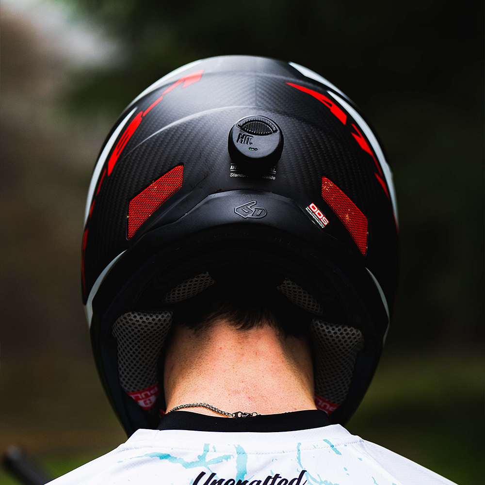 A close up view of the HIT device attached to the back of a downhill mtb full face helmet