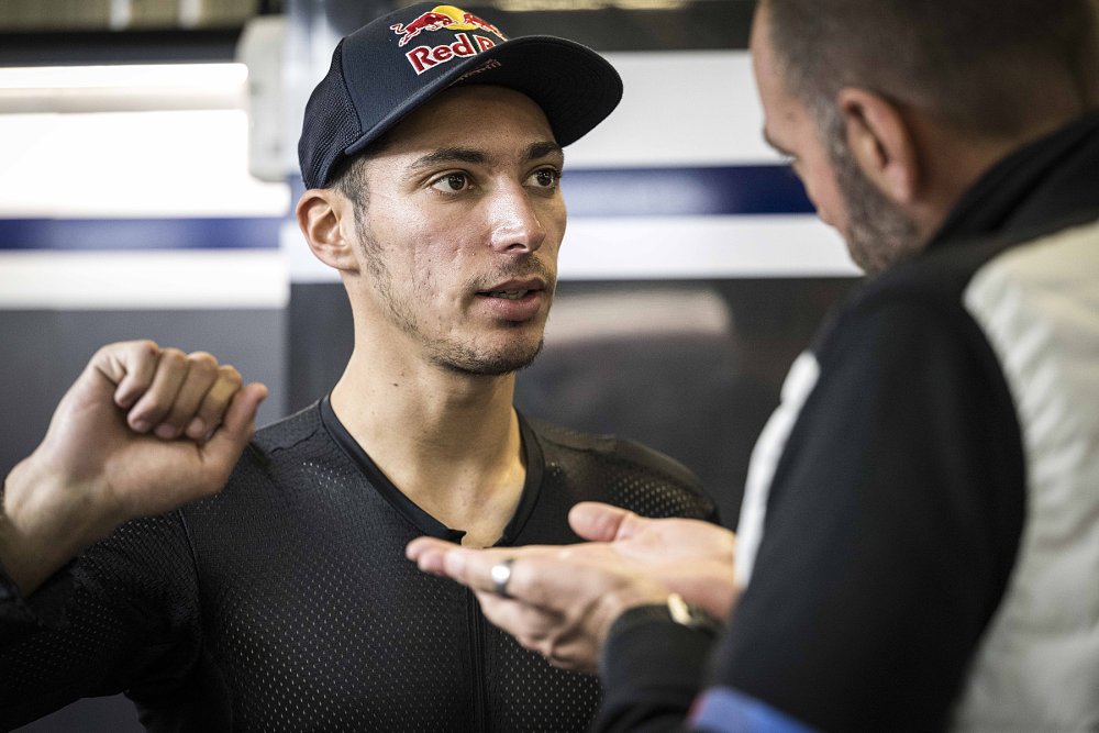 Razgatlıoğlu in the paddock making a throttle-twising motion with his right hand