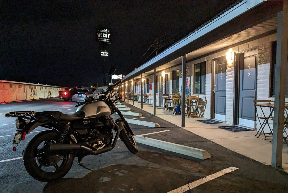 Moto Guzzi parked outside a small motel at night