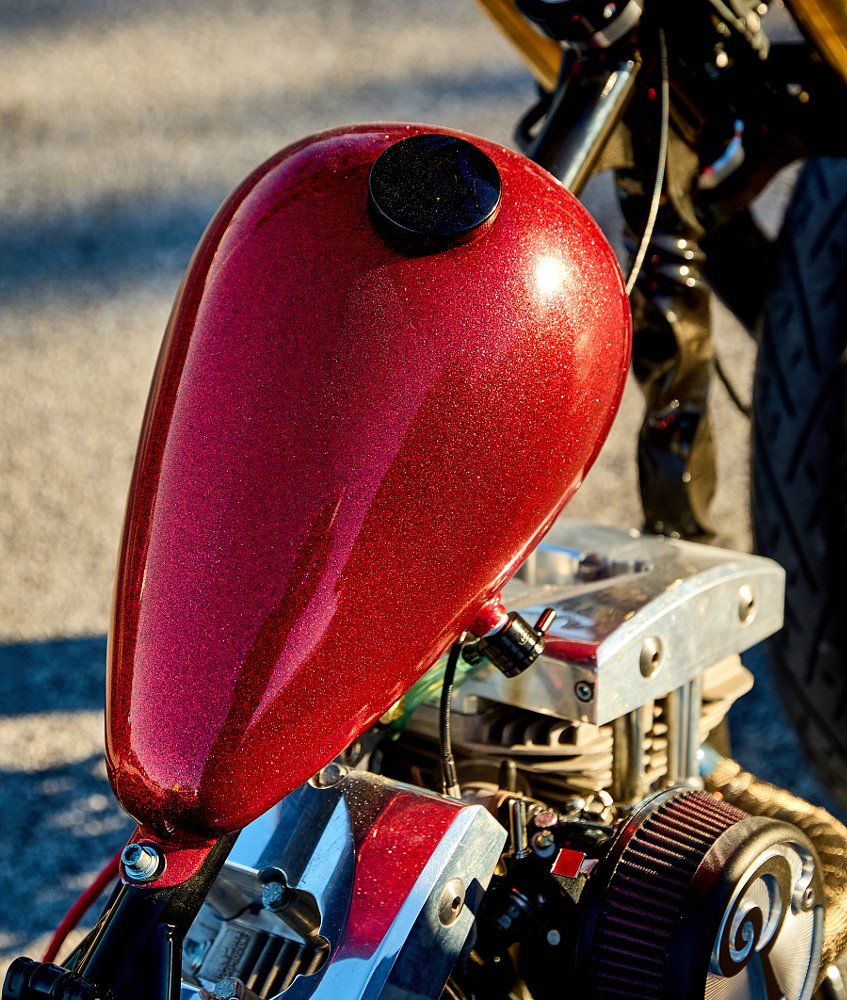 photo of red metalflake gas tank in the sun