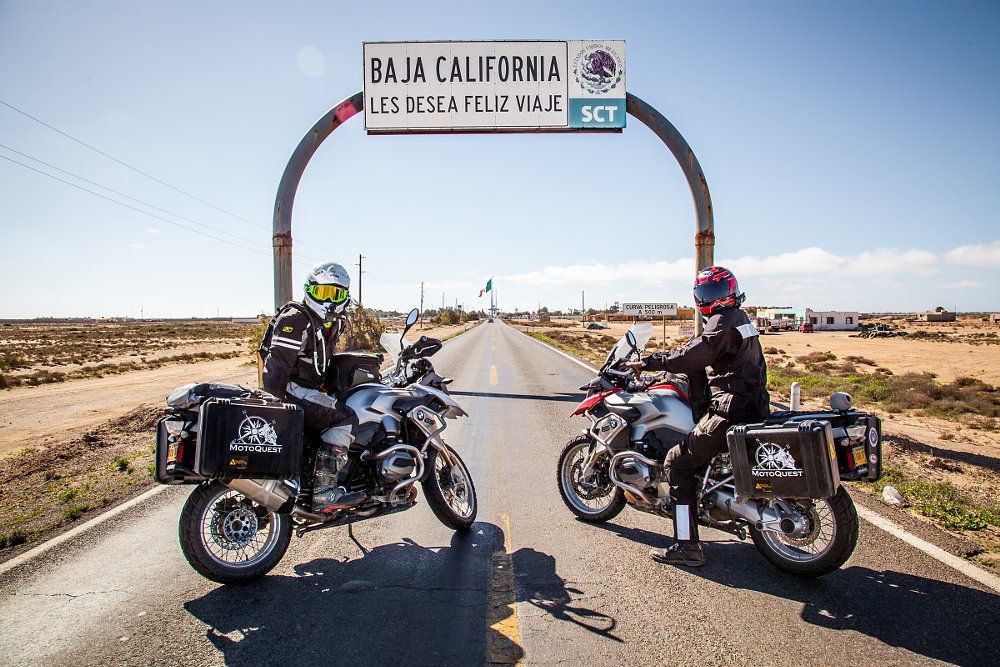 riders under a welcome to Baja sign