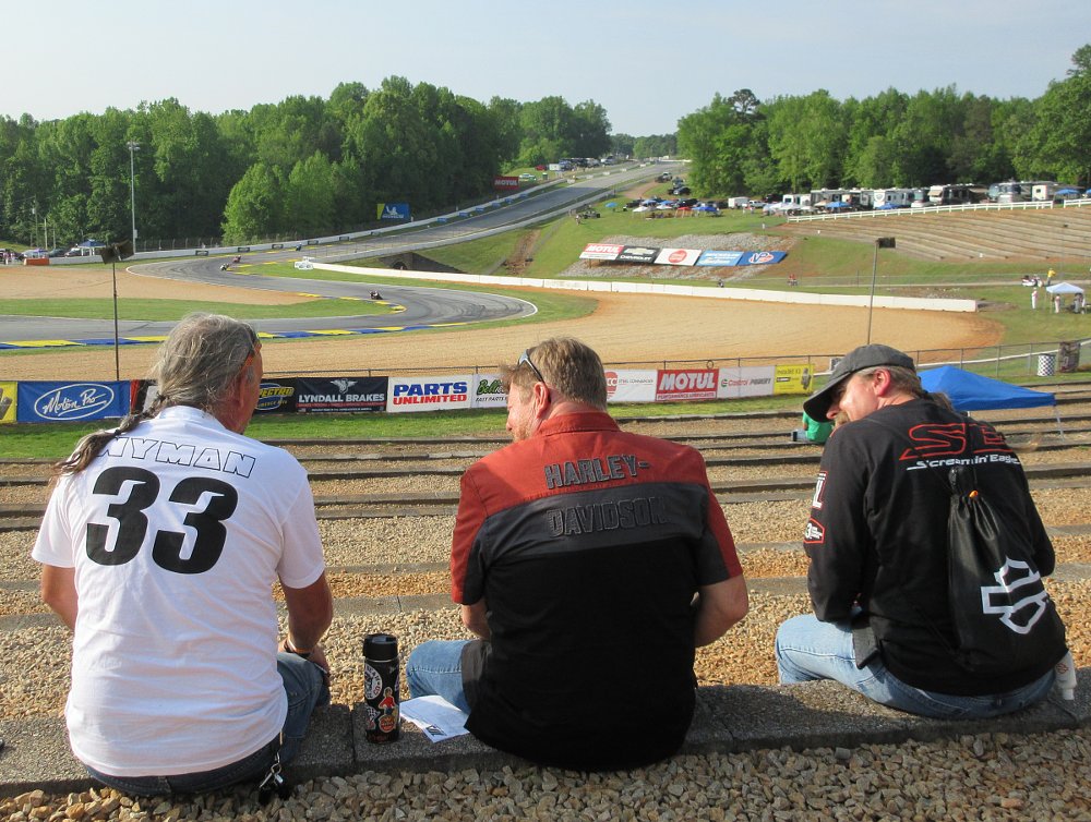 three fans wearing Harley-Davidson shirts on the bleachers overlooking Road Atlanta race track