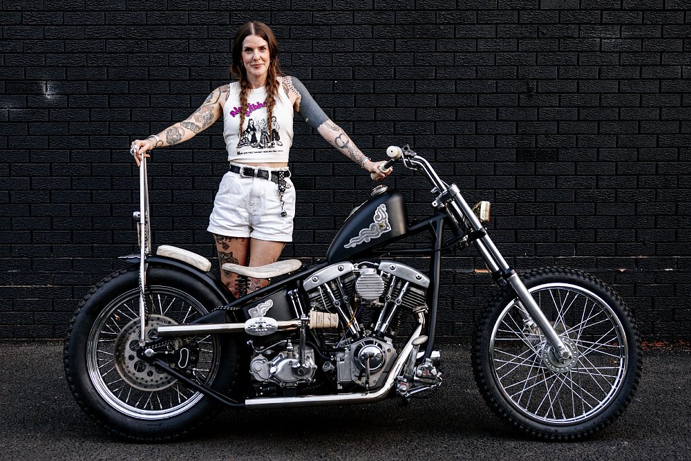 Sami Greystone posing for a studio photo with her custom motorcycle