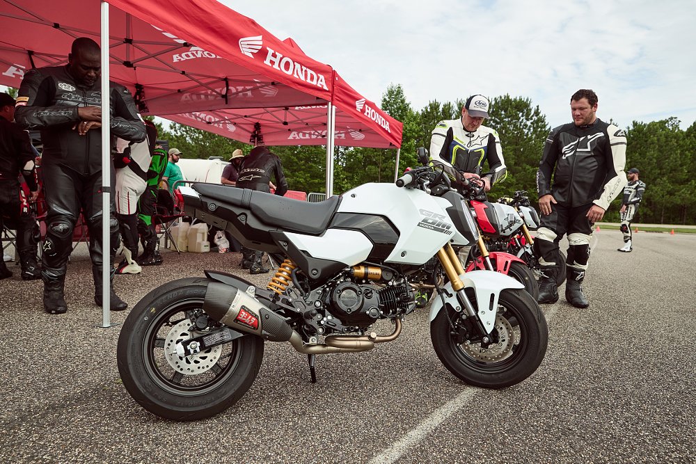 A race-prepped Grom parked in front of a canopy in the pits