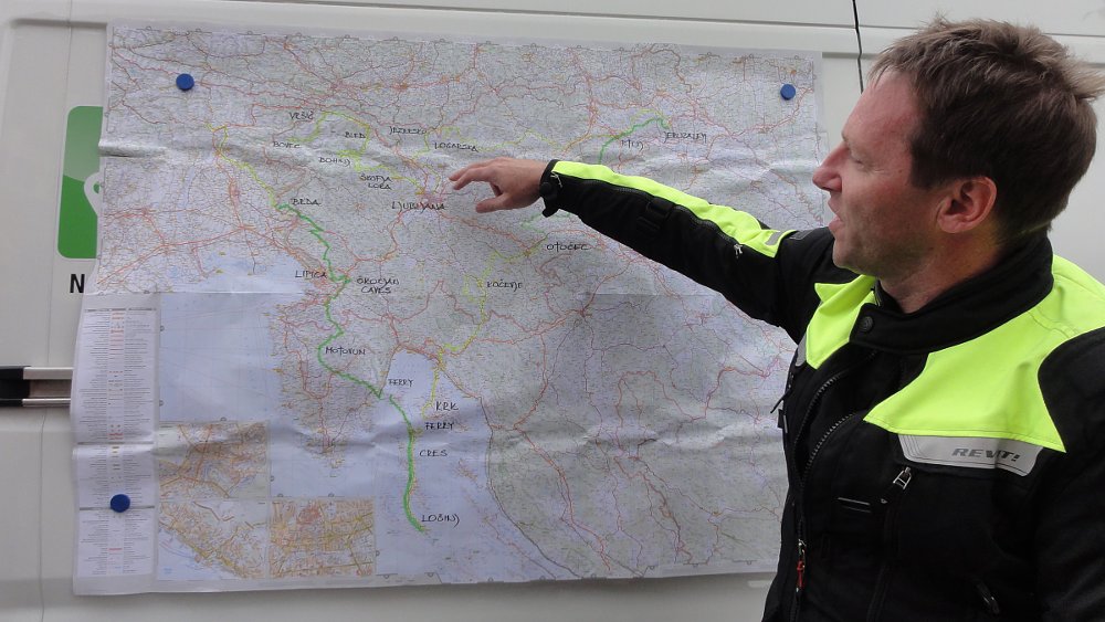 guide pointing to a wall map to explain the day's route