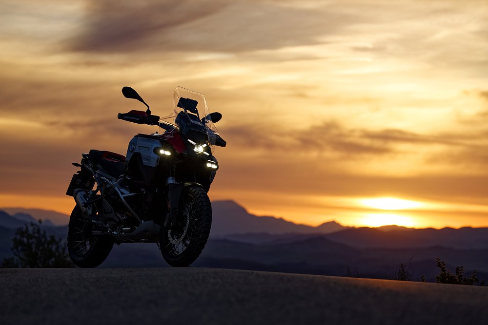 motorcycle parked in front of a sunset