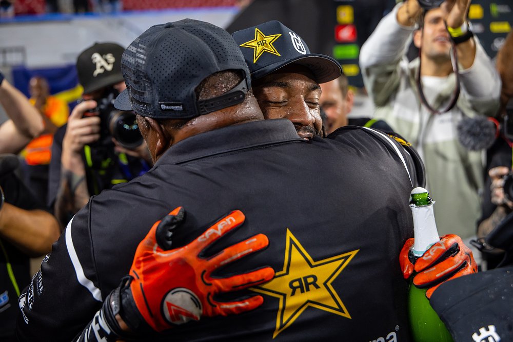 a smiling Malcolm Stewart gets a hug from his father after the race