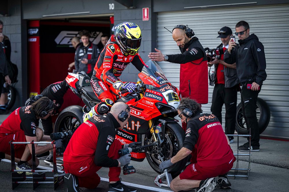 Ducati crew practices a tire change with Bautista sitting on the motorcycle