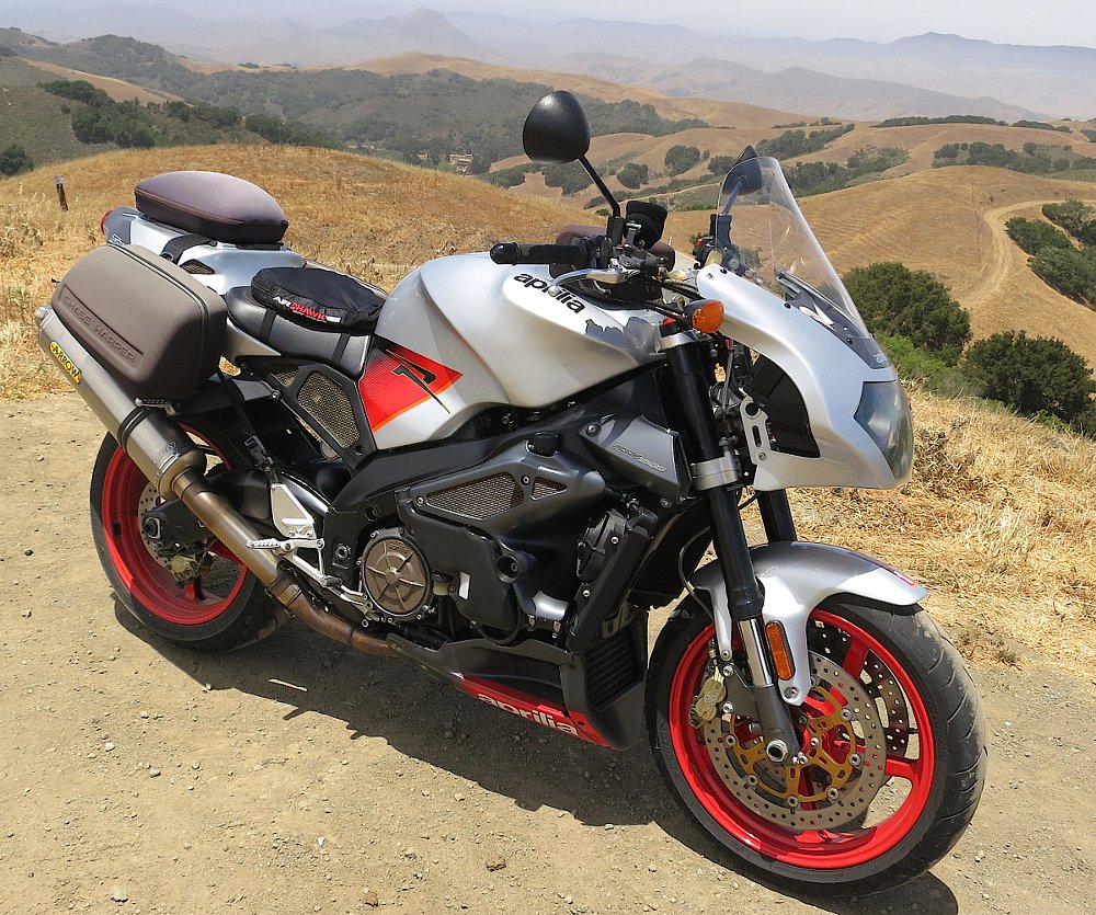 Aprilia Tuono parked at an overlook with dry hills in the background