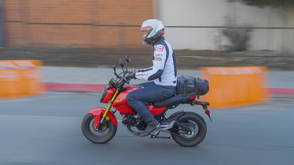 Honda Grom riding down a city street.