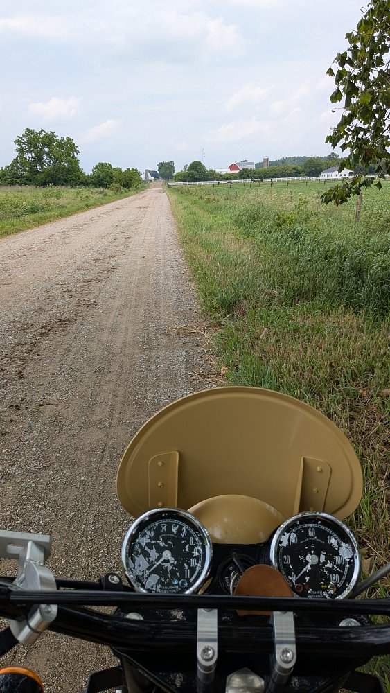 view of a dirt farming road going off into the distance, seen from the seat of the Janus Gryffin