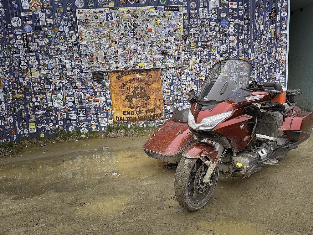 Daub's Gold Wing and sidecar in front of a sign at the end of the Dalton Highway in Deadhorse, Alaska